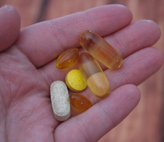 “자꾸 눕고 싶어요”… 에너지가 바닥나는 이유는 ‘비타민 결핍’일 수 있습니다 person holding medication pills