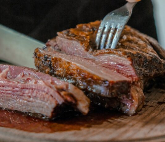 “손톱이 갈라지고 머리카락이 빠지는 이유, 철분 때문일 수 있습니다” person slicing a meat on brown wooden board