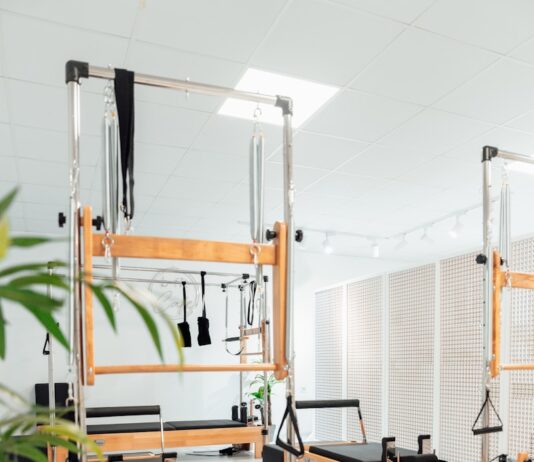 신체와 마음을 강화하는 필라테스 a room filled with lots of machines and a plant