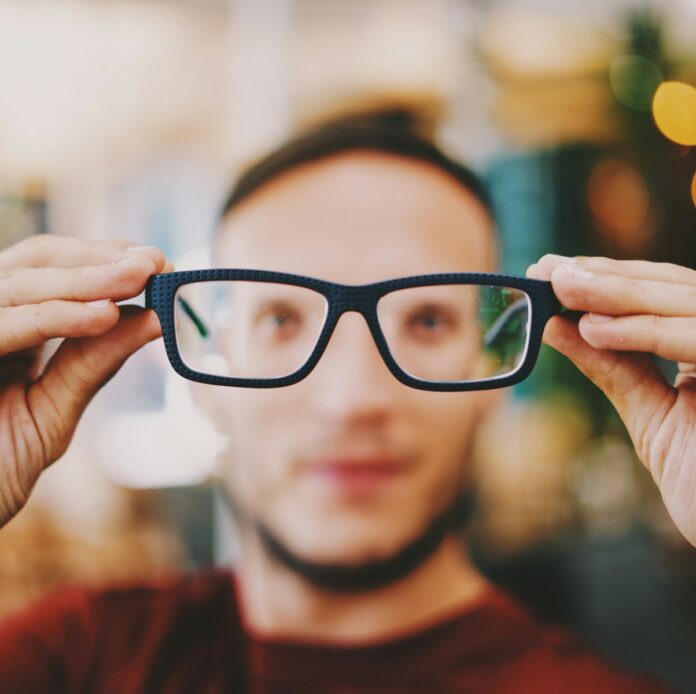 Photo by Nonsap Visuals person holding eyeglasses with black frames
