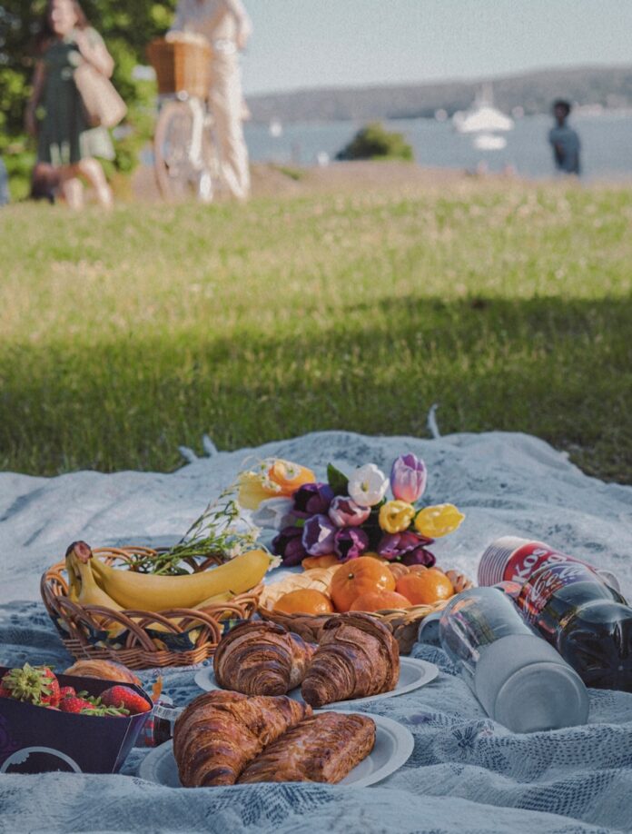 Photo by Zubayer Pranto a picnic blanket with food and drinks on it