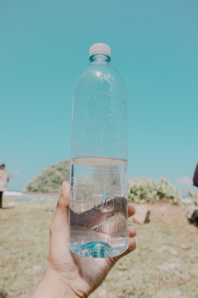 person holding clear plastic bottle