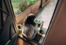 일상에 스며든 만성피로, 새로운 루틴으로 활력을 찾다 Woman sitting on balcony with smartphone