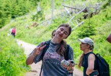 현대인을 위한 적정 걷기 습관, 건강도 시간도 잡는다 Young woman makes peace sign on a forest trail